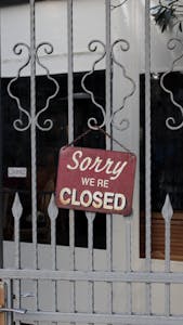 Rustic 'Sorry We're Closed' sign hanging on a metal gate in İstanbul.
