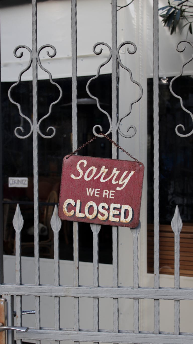 Rustic 'Sorry We're Closed' sign hanging on a metal gate in İstanbul.