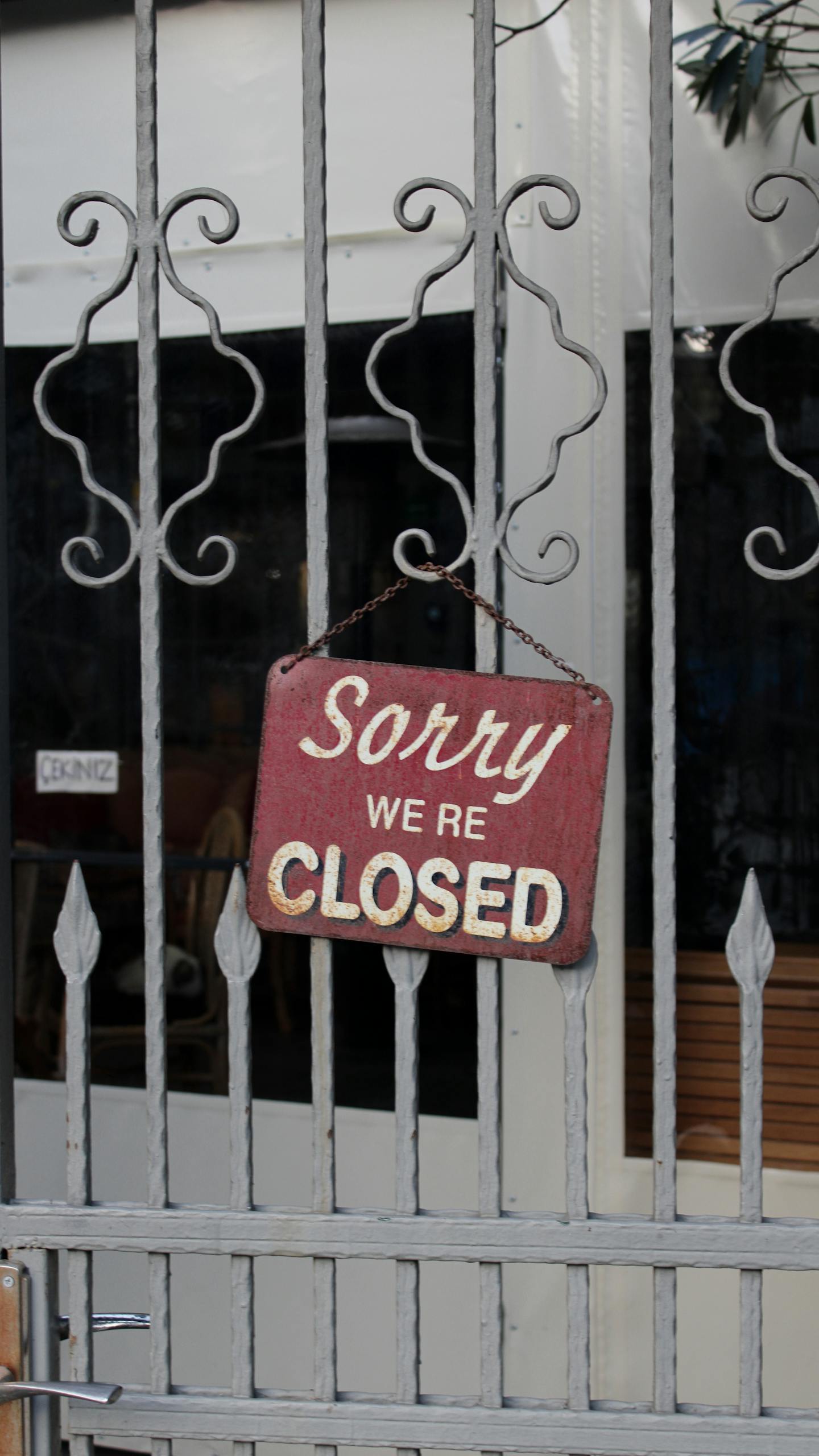 Rustic 'Sorry We're Closed' sign hanging on a metal gate in İstanbul.